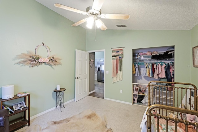 bedroom with stainless steel refrigerator with ice dispenser, vaulted ceiling, light colored carpet, and a closet