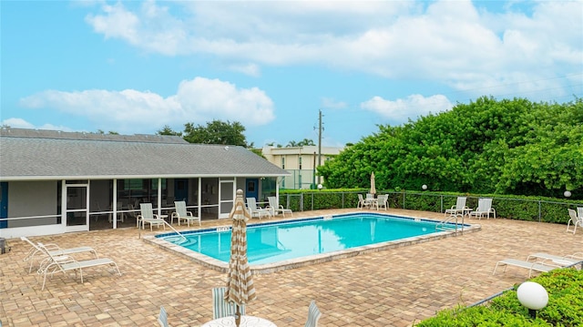 view of pool with a patio area and a sunroom