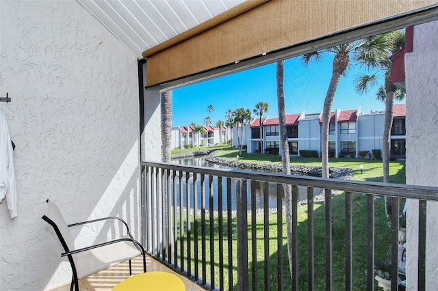 balcony featuring a residential view and a water view