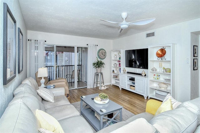 living room featuring ceiling fan, visible vents, and wood finished floors