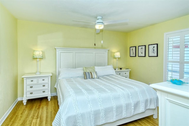 bedroom featuring light wood-type flooring, a ceiling fan, and baseboards