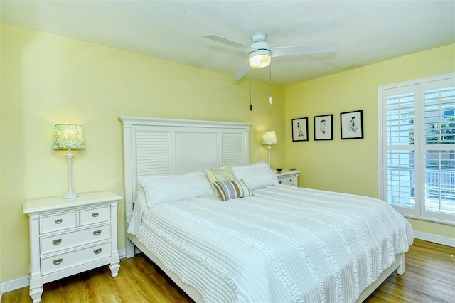 bedroom featuring ceiling fan, baseboards, and wood finished floors