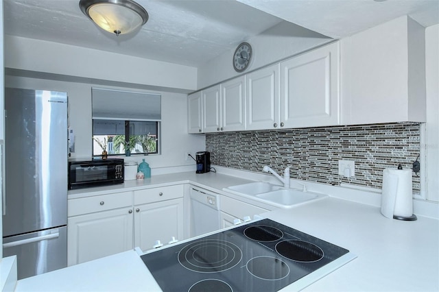 kitchen with a sink, white cabinets, light countertops, freestanding refrigerator, and dishwasher