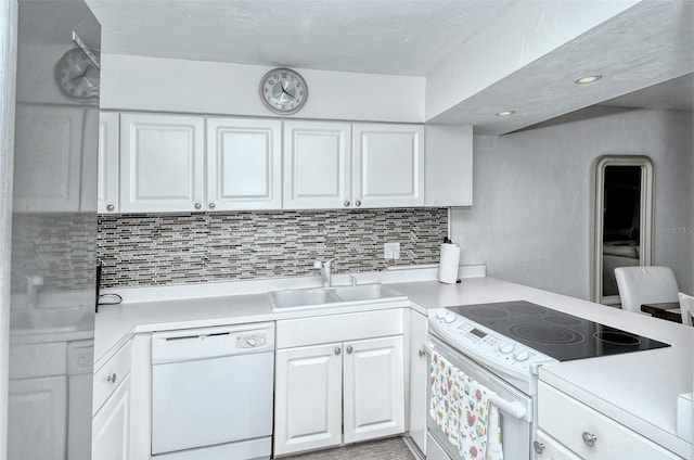 kitchen featuring light countertops, decorative backsplash, white cabinets, a sink, and white appliances