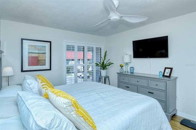 bedroom with baseboards, a ceiling fan, and light wood-style floors