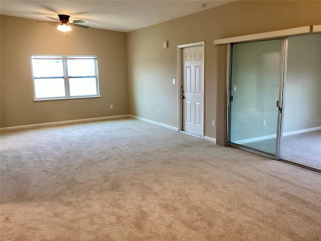 unfurnished room with ceiling fan and light carpet