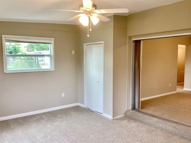 unfurnished bedroom featuring ceiling fan, a closet, and light carpet