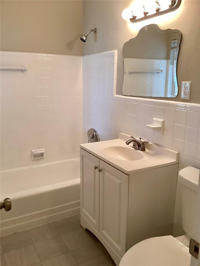 full bathroom featuring tiled shower / bath combo, tile patterned flooring, vanity, tile walls, and toilet