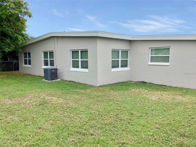 view of side of property with a lawn and central air condition unit