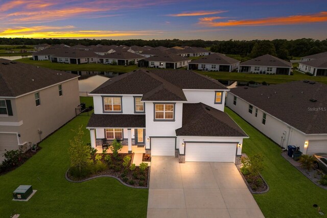 view of front of home with a garage and a lawn