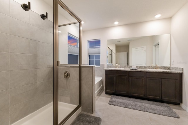 bathroom featuring independent shower and bath, dual vanity, and tile patterned floors