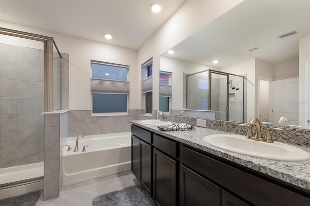 bathroom with double vanity, tile patterned floors, and separate shower and tub