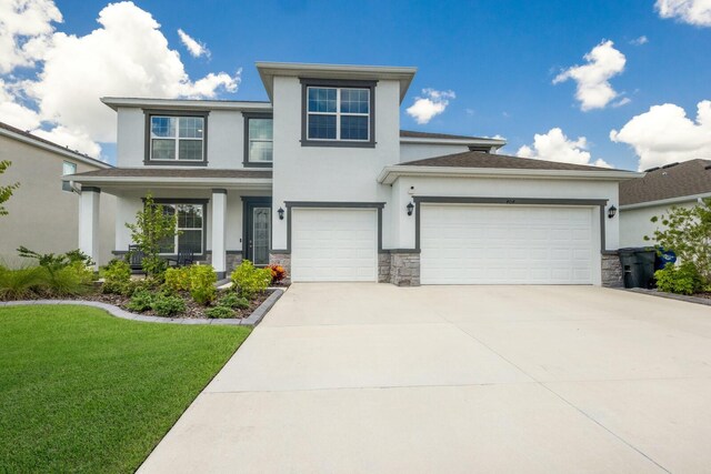 prairie-style home featuring a garage and a front lawn