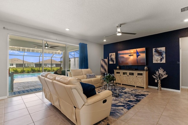 tiled living room featuring a textured ceiling and ceiling fan