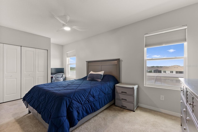 carpeted bedroom with ceiling fan and a closet