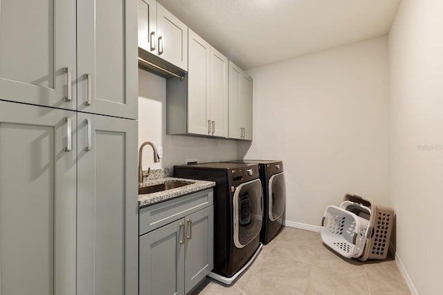 laundry room featuring sink, cabinets, light tile patterned floors, and separate washer and dryer