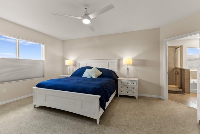 carpeted bedroom featuring ensuite bath and ceiling fan