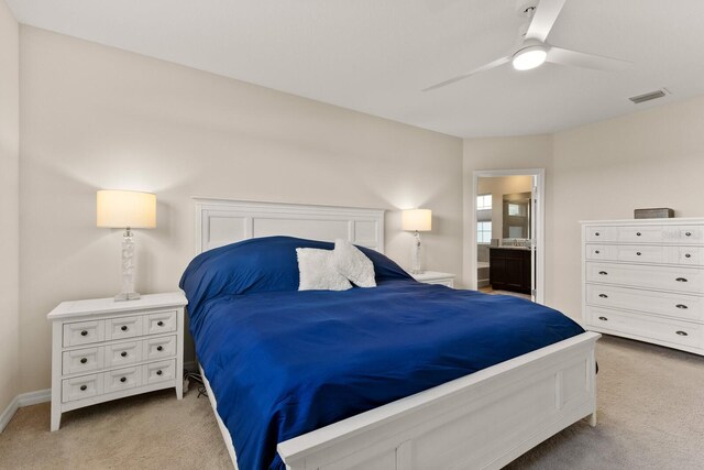 carpeted bedroom featuring ensuite bath and ceiling fan