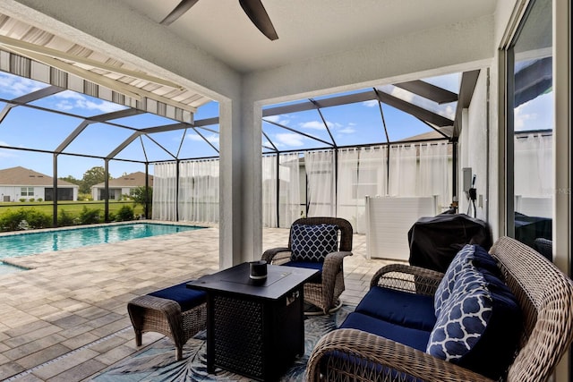 view of patio featuring grilling area, ceiling fan, and glass enclosure