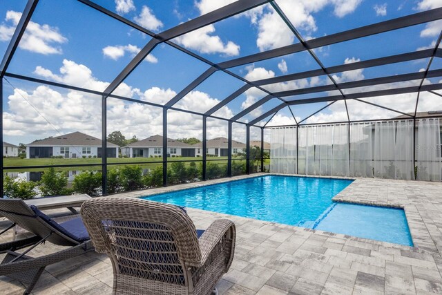 view of swimming pool featuring a patio area and glass enclosure