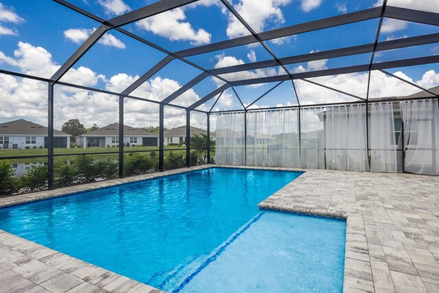 view of swimming pool featuring a patio area and a lanai