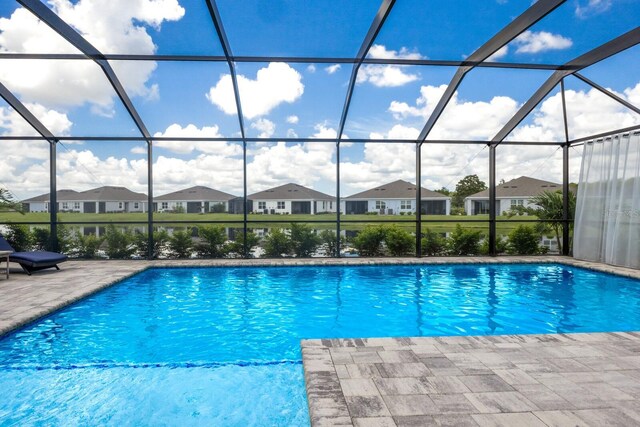 view of swimming pool with a patio and glass enclosure