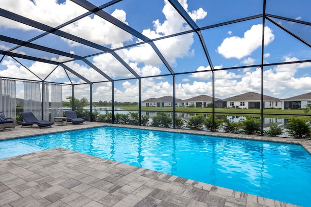 view of swimming pool with a patio area, a water view, and glass enclosure