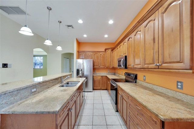 kitchen featuring light stone countertops, appliances with stainless steel finishes, sink, light tile patterned floors, and hanging light fixtures