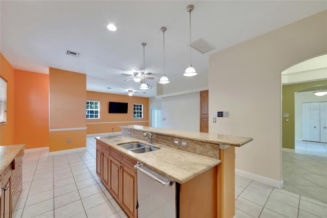 kitchen featuring ceiling fan, sink, stainless steel dishwasher, a center island with sink, and light tile patterned floors