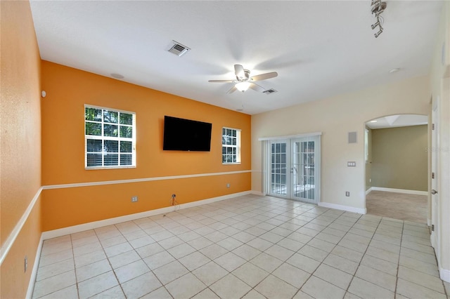 empty room with ceiling fan, light tile patterned floors, and french doors