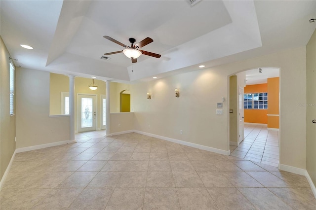 spare room with a raised ceiling, ceiling fan, and light tile patterned floors