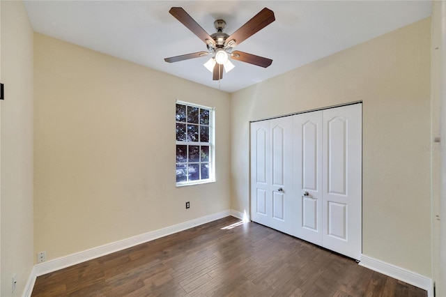 unfurnished bedroom featuring dark hardwood / wood-style flooring, a closet, and ceiling fan