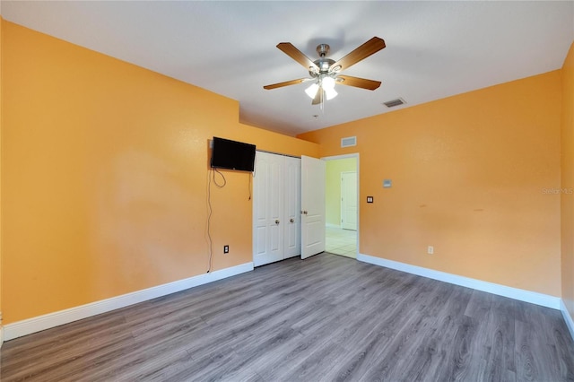 empty room featuring wood-type flooring and ceiling fan