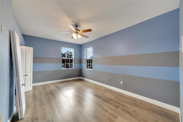 spare room with ceiling fan and wood-type flooring