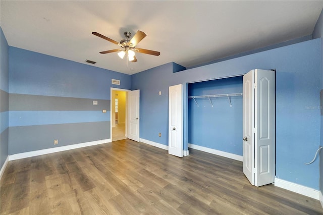 unfurnished bedroom with hardwood / wood-style floors, ceiling fan, and a closet