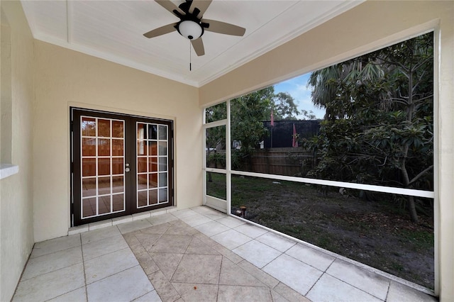 unfurnished sunroom with ceiling fan and french doors