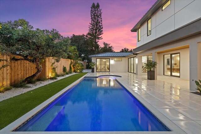 view of pool featuring a patio area, a fenced backyard, a fenced in pool, and a hot tub