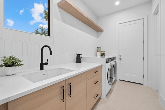 laundry room featuring a sink, laundry area, light tile patterned floors, and washer and dryer