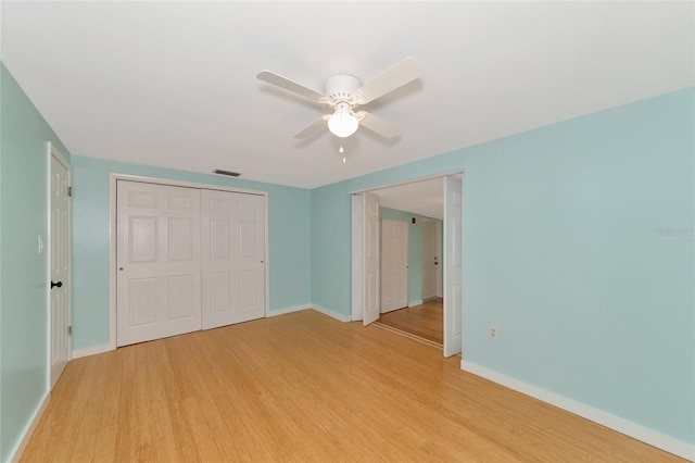 unfurnished bedroom featuring ceiling fan, light hardwood / wood-style floors, and a closet