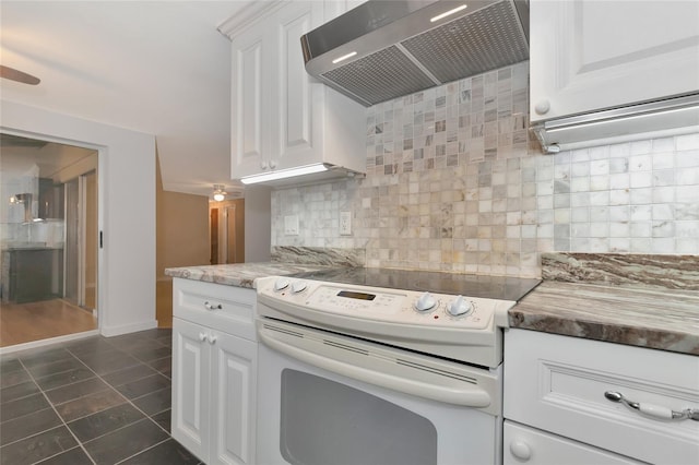 kitchen with white cabinets, white range with electric stovetop, wall chimney exhaust hood, and decorative backsplash