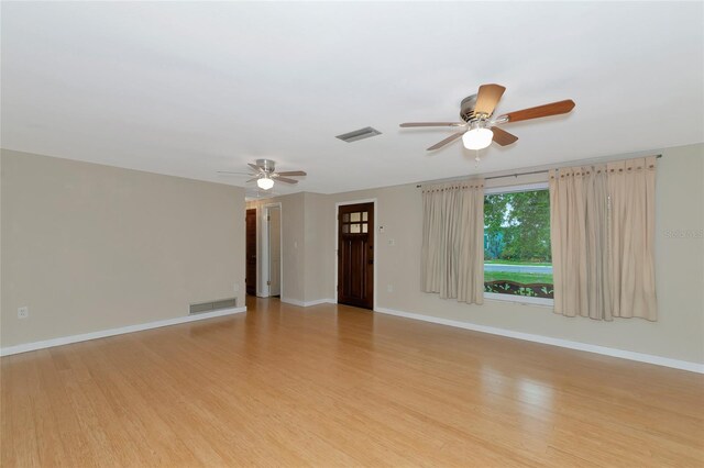 empty room with ceiling fan and light hardwood / wood-style flooring