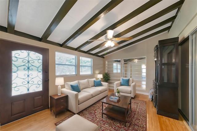 living room with ceiling fan, light wood-type flooring, and lofted ceiling with beams