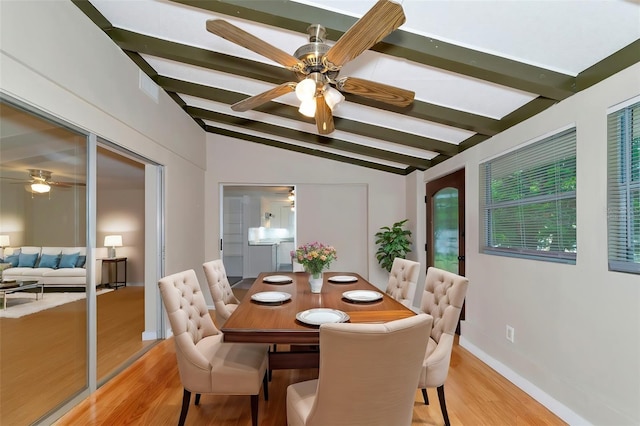 dining area featuring light wood-type flooring, ceiling fan, and vaulted ceiling with beams