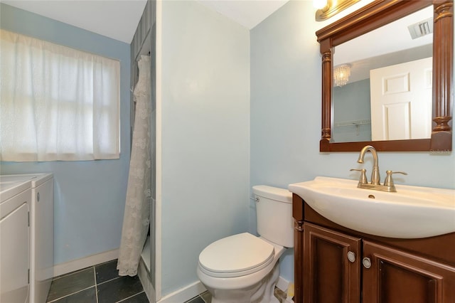 bathroom featuring separate washer and dryer, tile patterned floors, vanity, and toilet