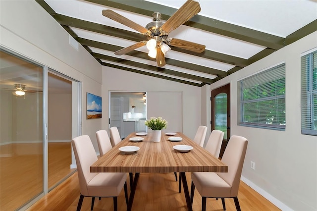 dining area with ceiling fan, light wood-type flooring, and vaulted ceiling with beams