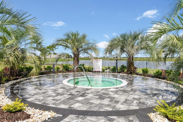 view of swimming pool featuring a hot tub