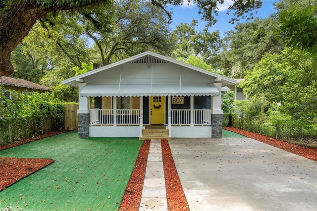 bungalow with a porch, a front yard, and fence