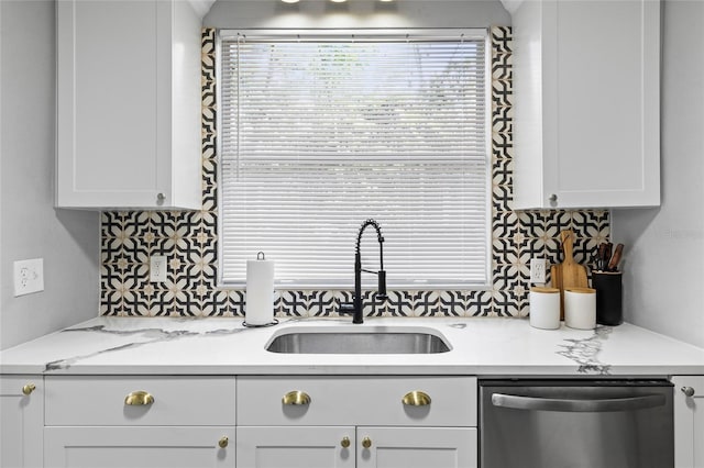 kitchen with a sink, white cabinetry, decorative backsplash, and stainless steel dishwasher