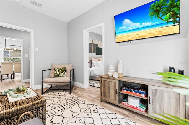 living area featuring baseboards, visible vents, and light wood-style floors