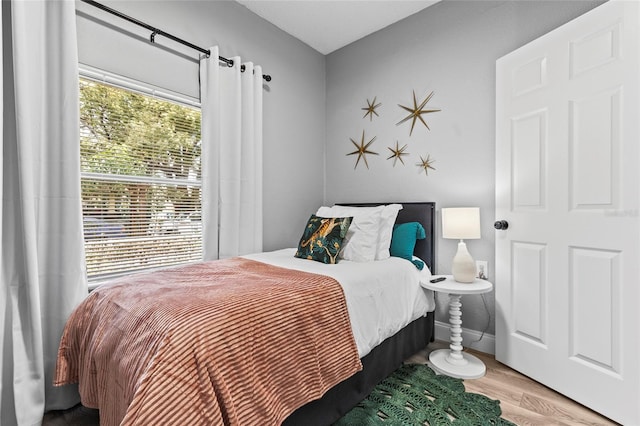 bedroom with baseboards and wood finished floors